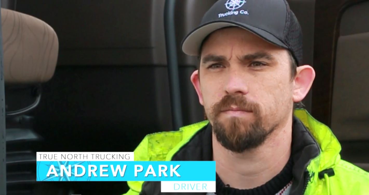 Close-up of a man wearing a cap and high-visibility jacket.